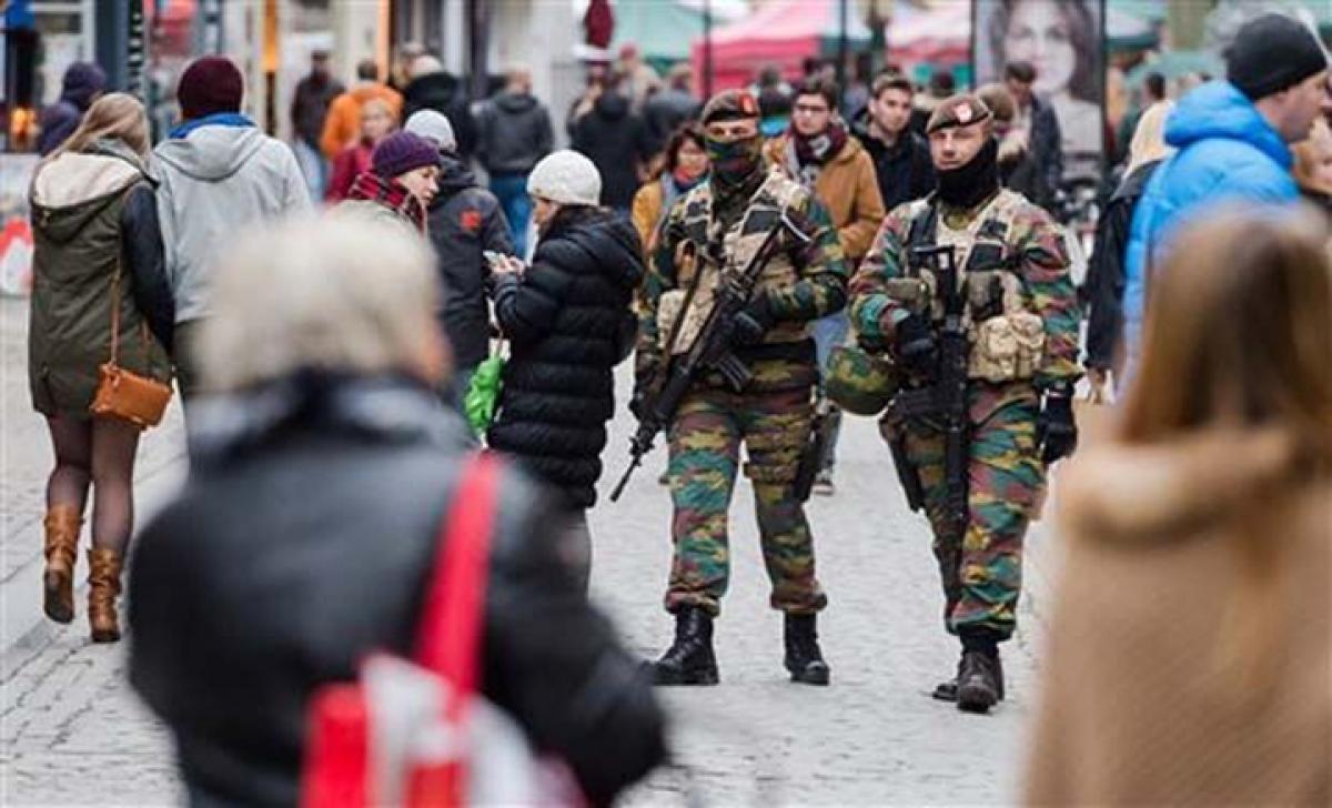 Belgium weighs extending lockdown as police hunt Paris attackers